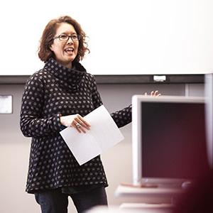 Female faculty memeber standing in front of class speaking